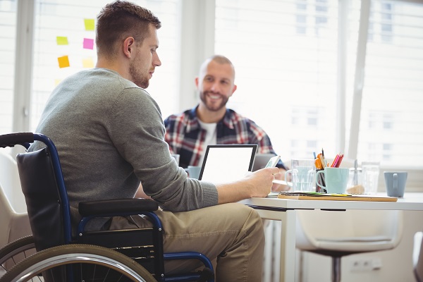 Travailleur handicapé qui travaille avec un collègue dans un bureau