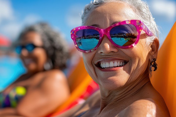 Des amis séniors profitent des rires et du soleil au bord de la piscine d'un parc aquatique