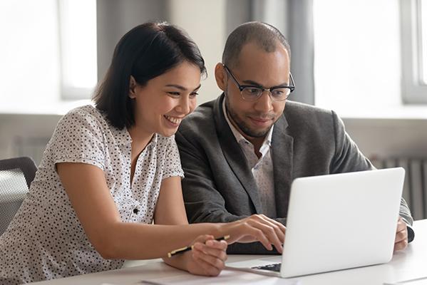 un couple de trentenaires qui regarde sur un ordinateur portable