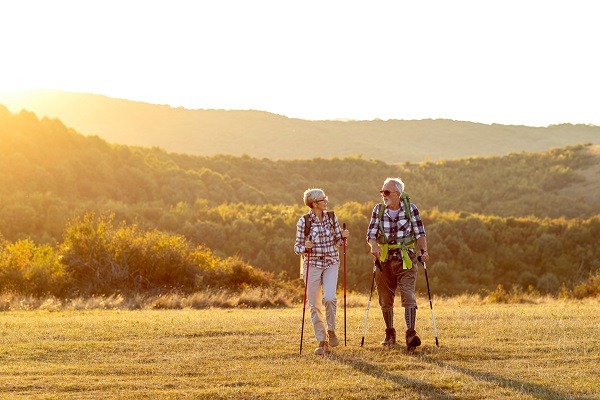 Couple de retraités qui randonne dans la nature avec des sacs à dos