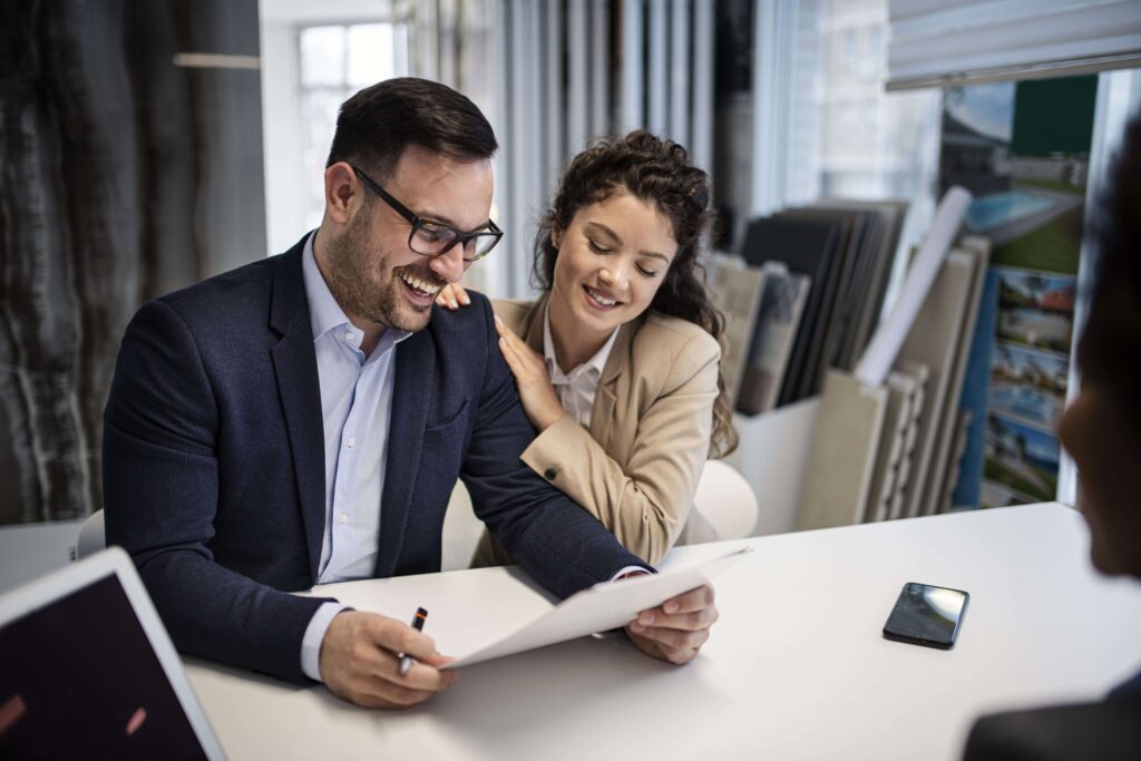 Jeune couple en train de signer un document.