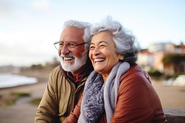 un couple de retraités souriant face à la mer