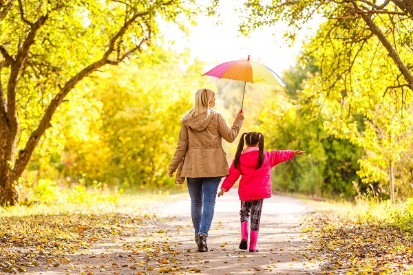 Jeune mère et sa petite fille en plein air dans des imperméables colorés