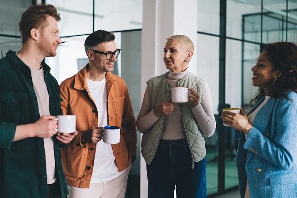 groupe de collègues de bureau discutant debout autour d'un café