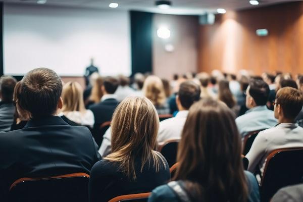 Des personnes de dos assises dans un auditorium