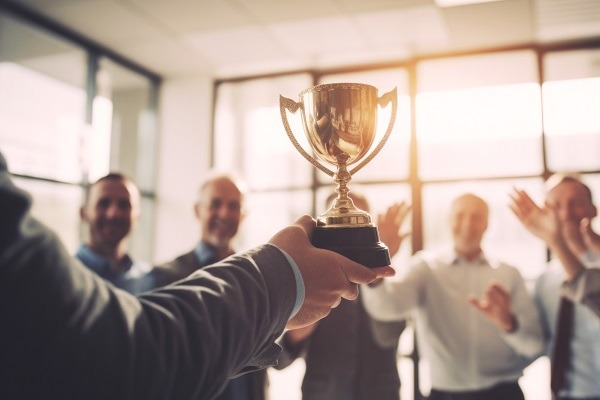 Équipe commerciale célébrant le trophée d'or. Concept de réussite et d'accomplissement équipe de bureau.